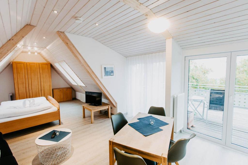 Schlafzimmer mit einem Bett und einem Tisch mit einem Schreibtisch in der Unterkunft Strandpension Mäder in Uhldingen-Mühlhofen