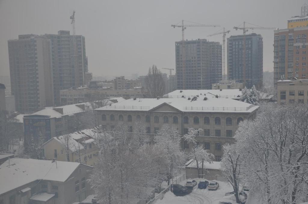 a city with snow covered trees and buildings at Hotel Trias in Kyiv