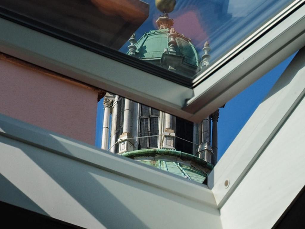 un edificio con campanario reflejado en una ventana en Le Quinte del Duomo en Como