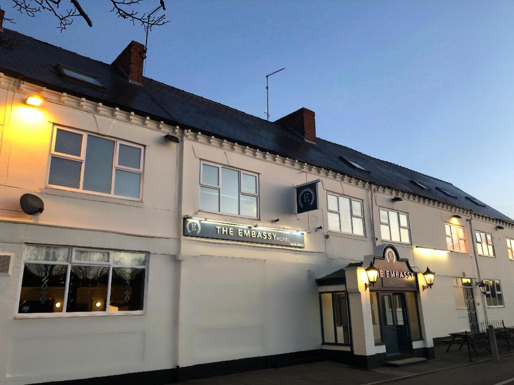 um edifício branco com uma placa na frente dele em The Embassy Hotel em Hull