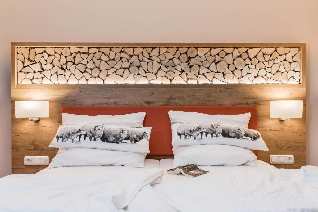 a bedroom with two beds with white pillows at Hotel Pension Fortuna in Bad Bevensen
