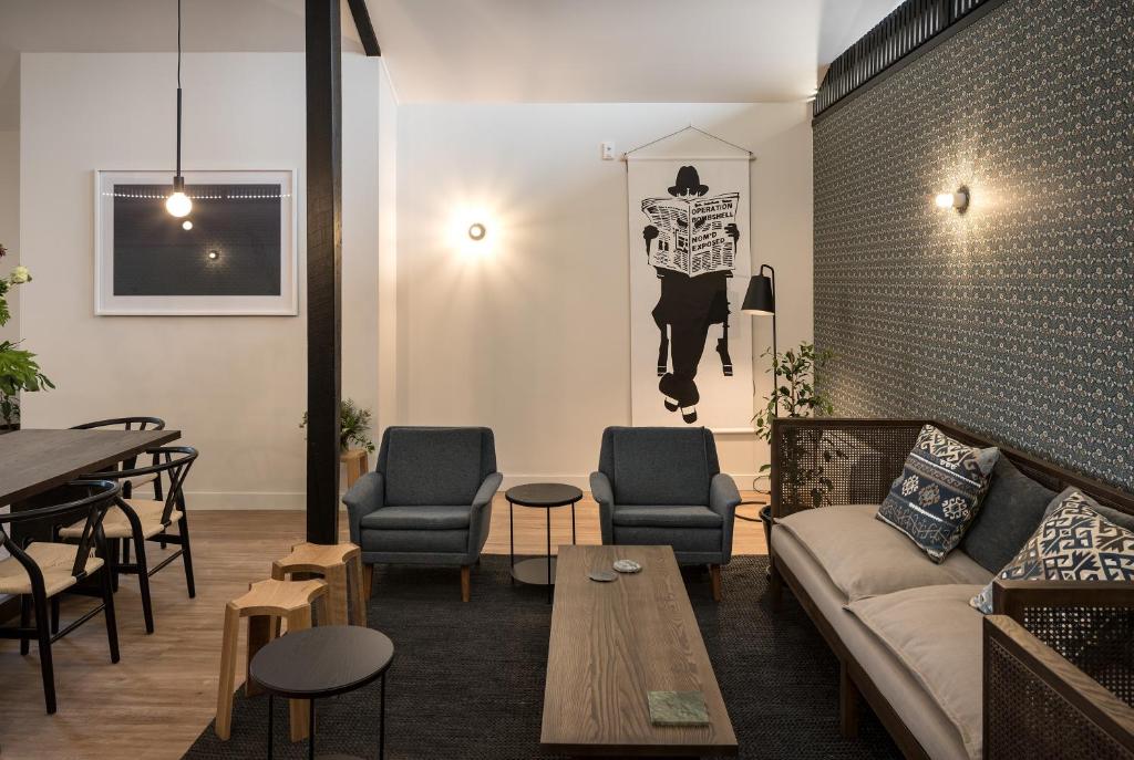 a living room with a couch and chairs and a table at The Chamberson in Dunedin
