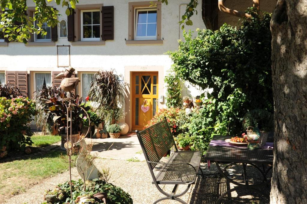 einen Garten mit einem Tisch und einer Bank vor einem Haus in der Unterkunft Gschwanderhof in Glottertal