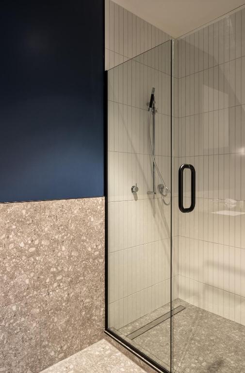 a shower with a glass door in a bathroom at The Chamberson in Dunedin