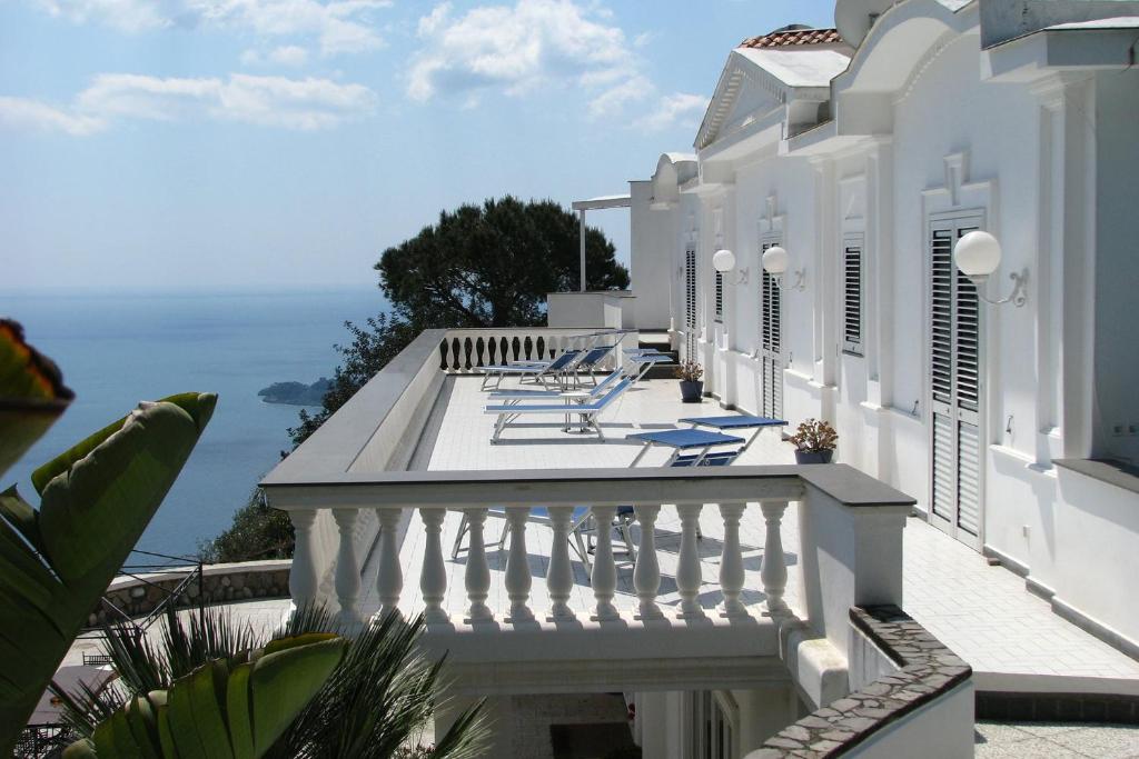 Biały dom z balkonem z widokiem na ocean w obiekcie Villa Lamaro w mieście Piano di Sorrento