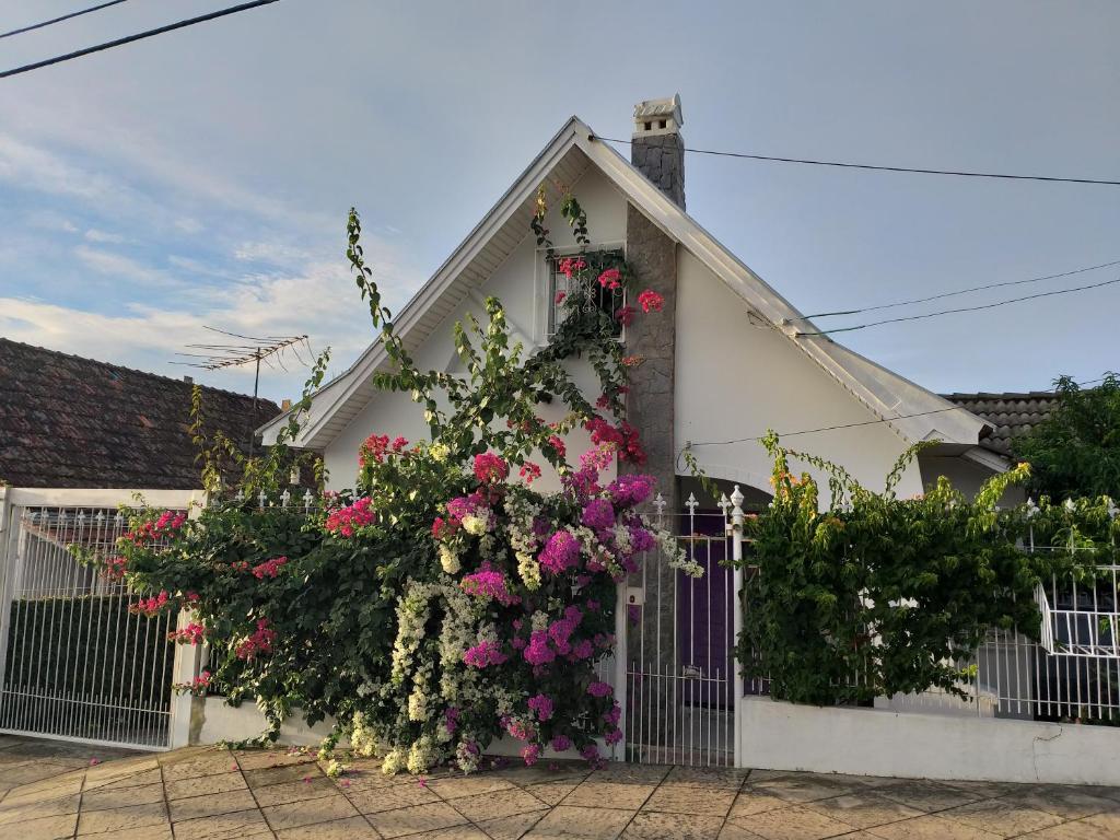 una casa con flores a un lado. en Norte Hospedagem, en Lages