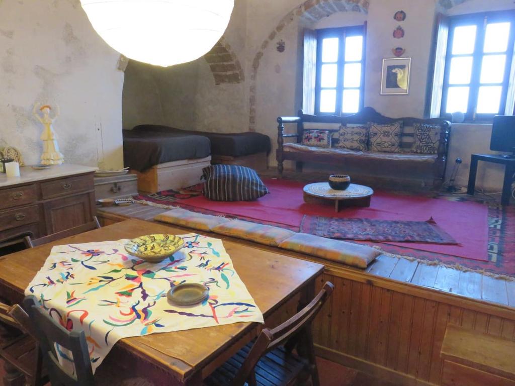 uma sala de estar com uma mesa e um sofá em Old Traditional House in the Castle of Monenvasia em Monemvasia
