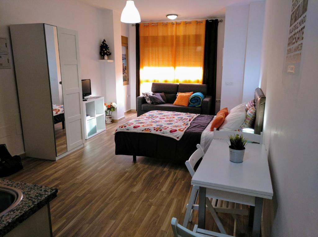 een kleine woonkamer met een bed en een bank bij Apartamento Domingo Lozano in Málaga
