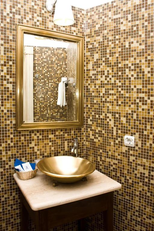 a bathroom with a gold sink and a mirror at Hotel Usadba in Kaliningrad