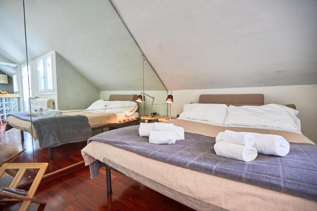 een slaapkamer met 2 bedden en handdoeken bij Sempione Cozy Studio in Milaan