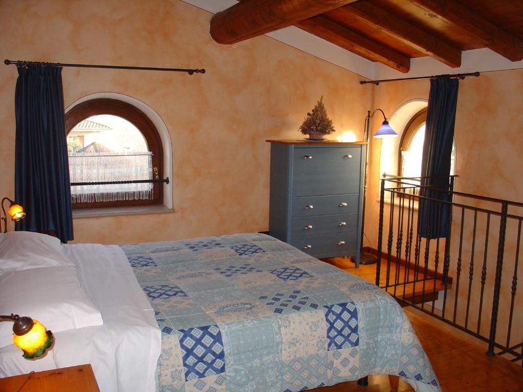 ein Schlafzimmer mit einem Bett mit einer blauen Kommode und einem Fenster in der Unterkunft Agriturismo Gian Galeazzo Visconti in Valeggio sul Mincio