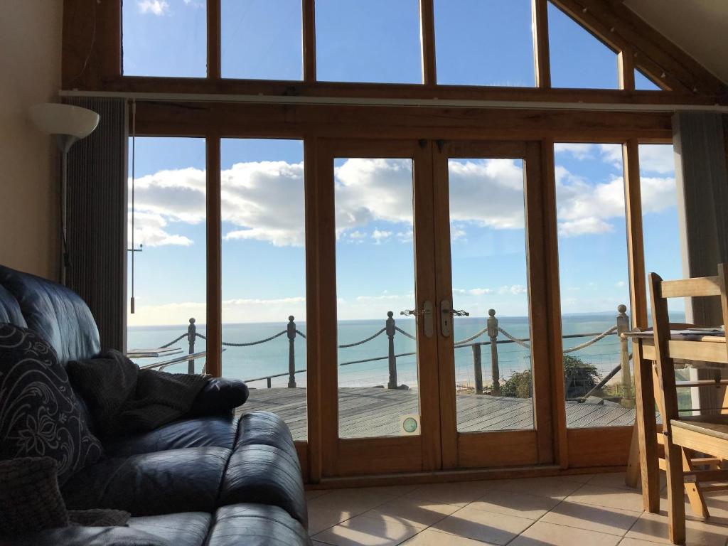 a living room with sliding glass doors with a view of the ocean at Beautiful Wales in Barmouth