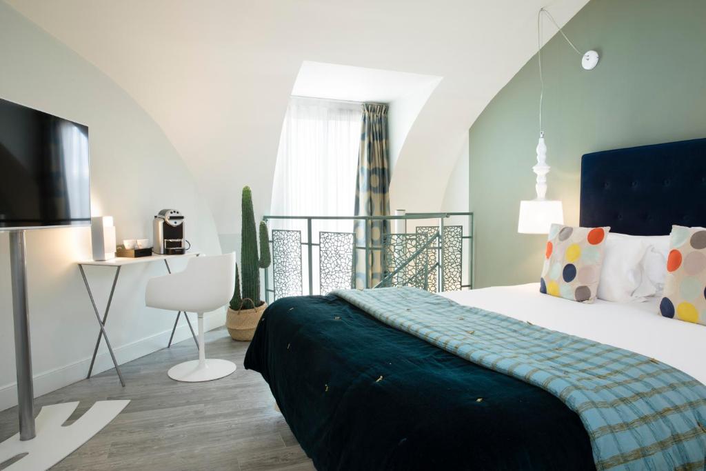 a bedroom with a large bed with a blue blanket at Hôtel Marais Hôme in Paris