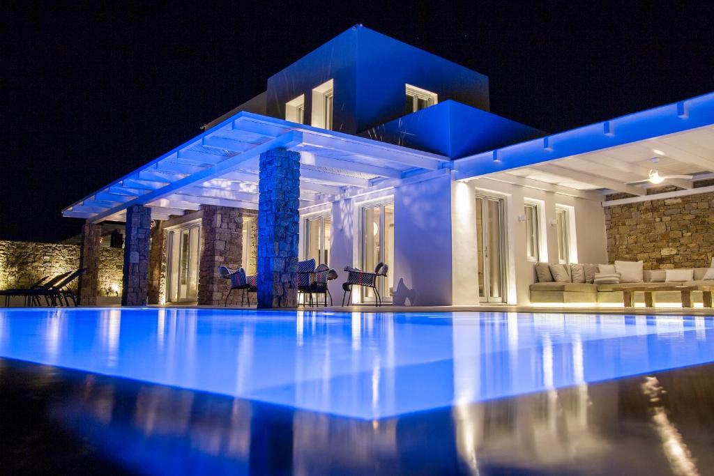 a villa with a swimming pool at night at Villa ANAIS 1 MYKONOS in Elia Beach