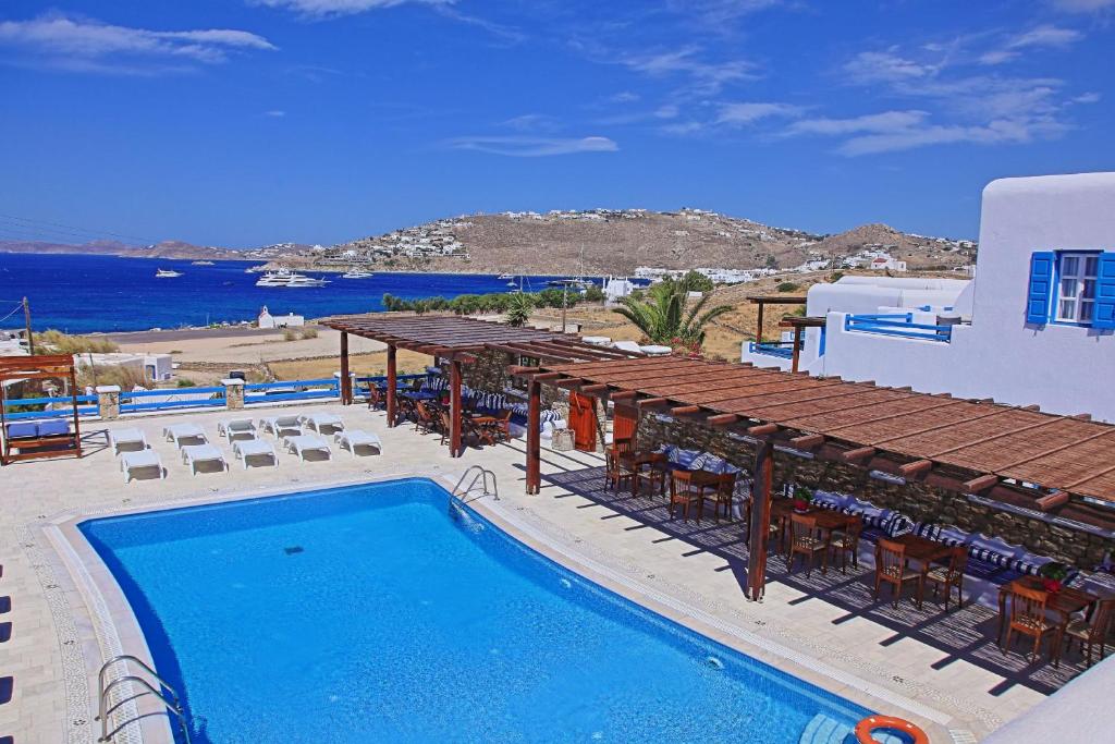 um resort com piscina, mesas e cadeiras em Maganos Apartments em Paraga