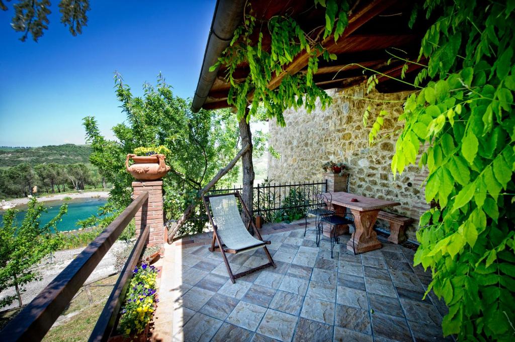 an outdoor patio with a wooden table and chairs at Agriturismo Palazzo Conti A in Pienza