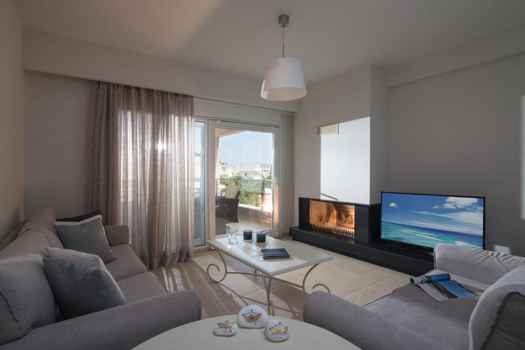 - un salon avec un canapé et une télévision dans l'établissement Gras Houses - Near to sandy beach, à Agia Pelagia