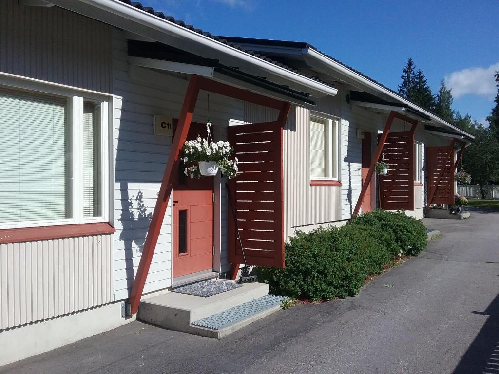 a house with a red door with a flower basket on it at Cozy two room apartment with sauna in Hyvinkää