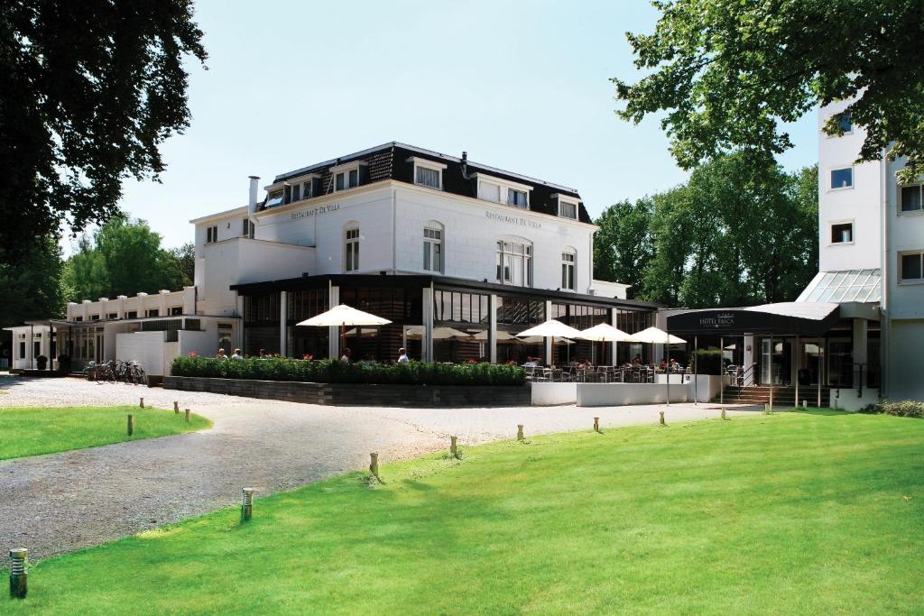 a large white building with umbrellas in front of it at Fletcher Hotel Restaurant Erica in Berg en Dal