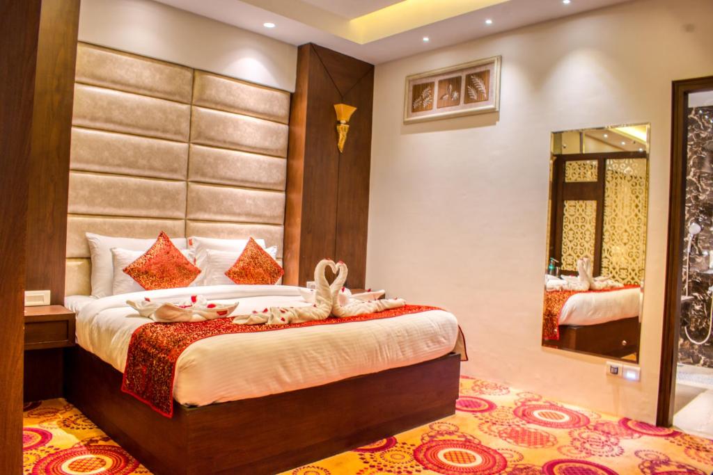 1 dormitorio con 1 cama grande y espejo en The Grand Ambassador en Phagwāra