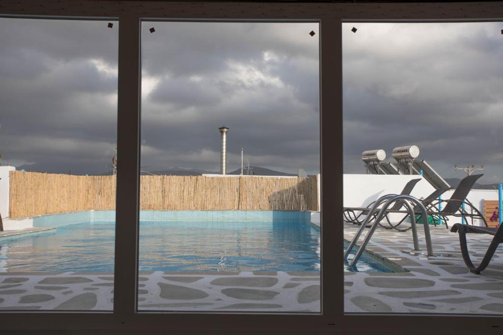 a view of a swimming pool through a window at Mare Naxia Hotel in Naxos Chora