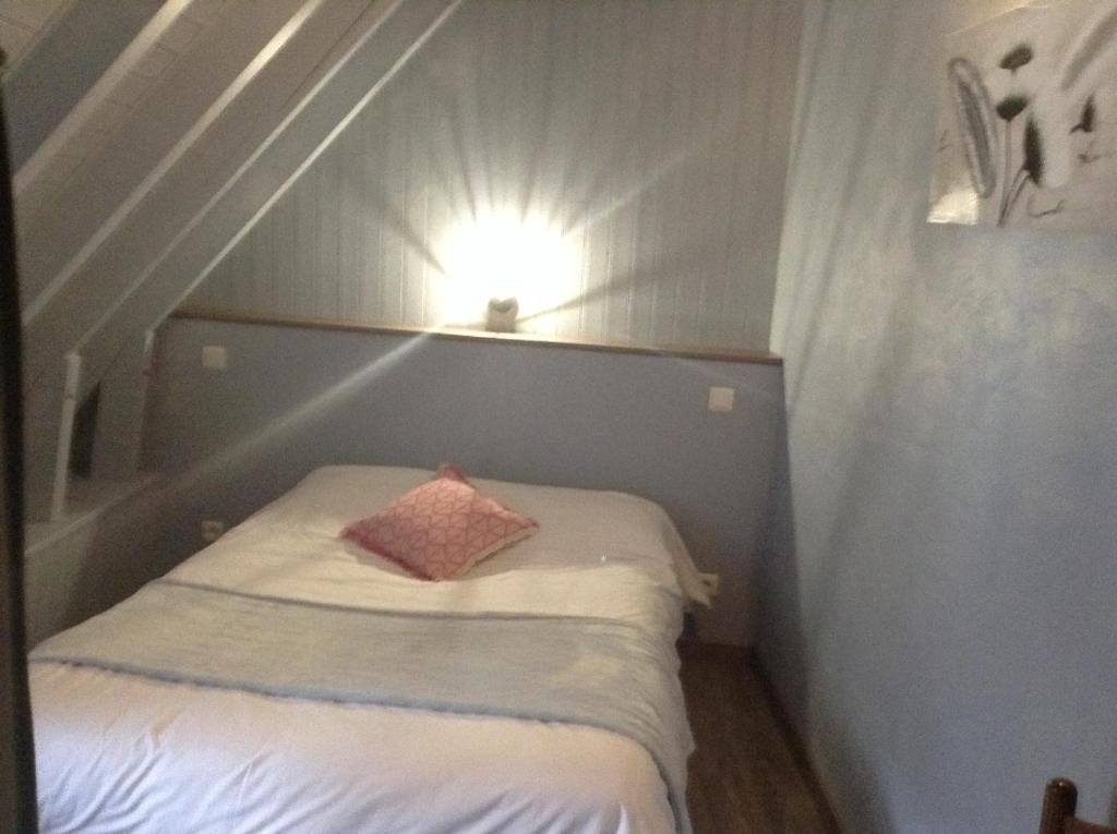 CreysseにあるGite Zoéのピンクの枕付きのベッドが備わる小さな客室です。