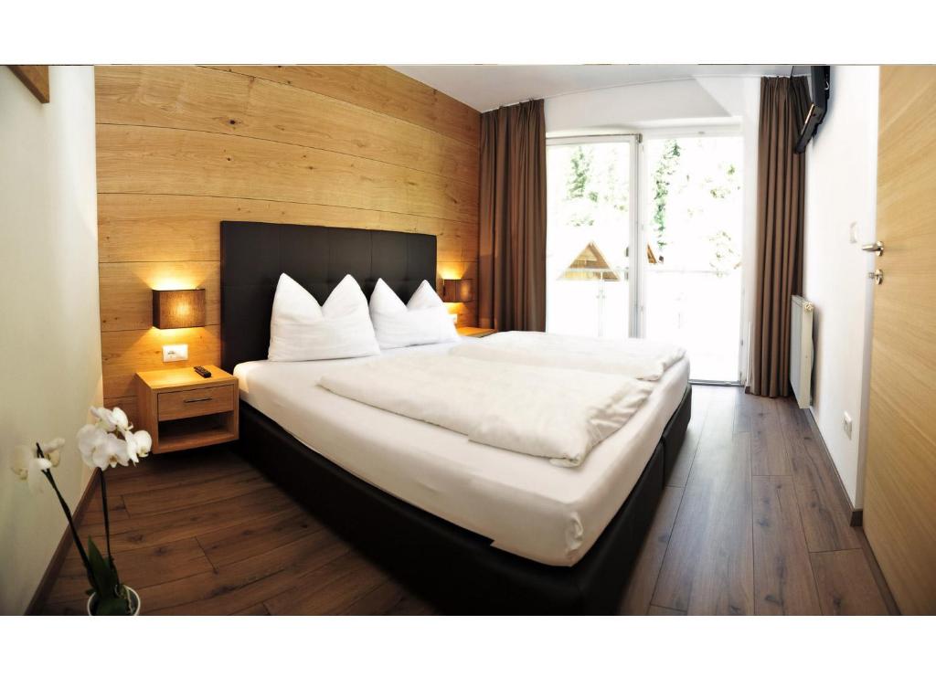 a bedroom with a large bed and a window at Apparthotel Central in Campo Tures