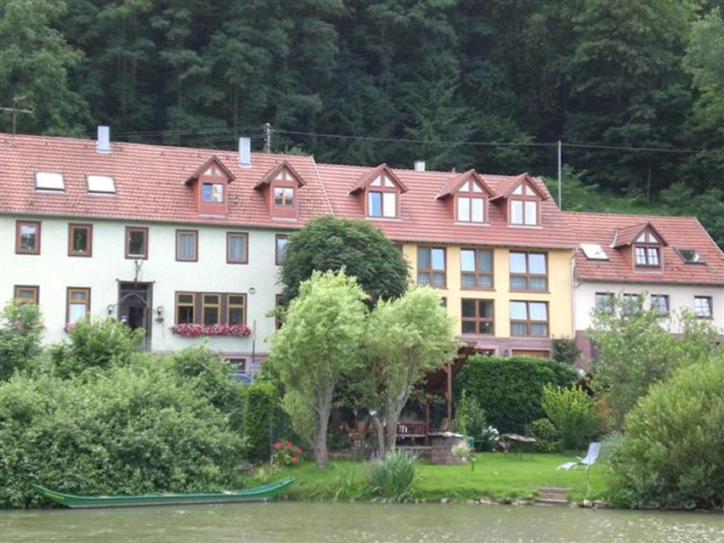 a large house next to a body of water at Gästehaus Martin in Gamburg