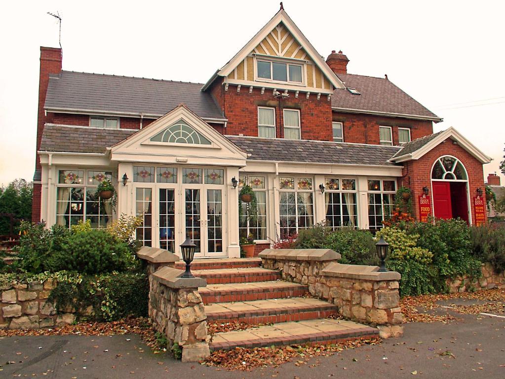 una casa con una escalera de piedra delante de ella en The Punchbowl Inn, en Thorne