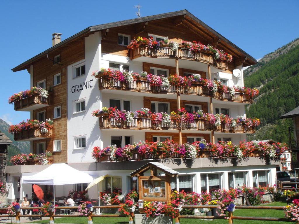 a large building with flowers on the balconies at B&B Haus Granit Saas Grund in Saas-Grund