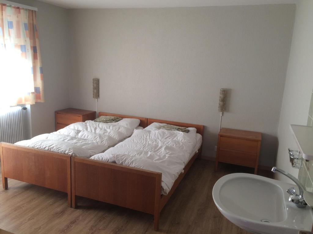a bedroom with a bed and a sink and a tub at B&B Haus Granit Saas Grund in Saas-Grund