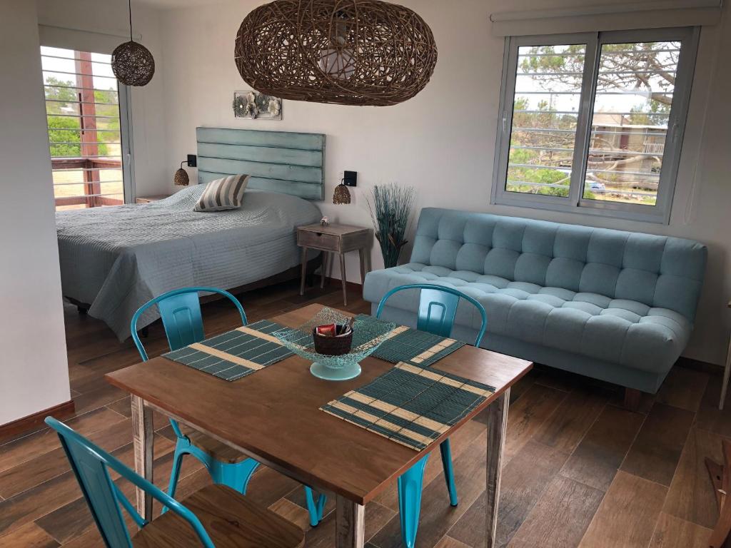 a living room with a bed and a table and a couch at Los Caracoles in Punta Del Diablo