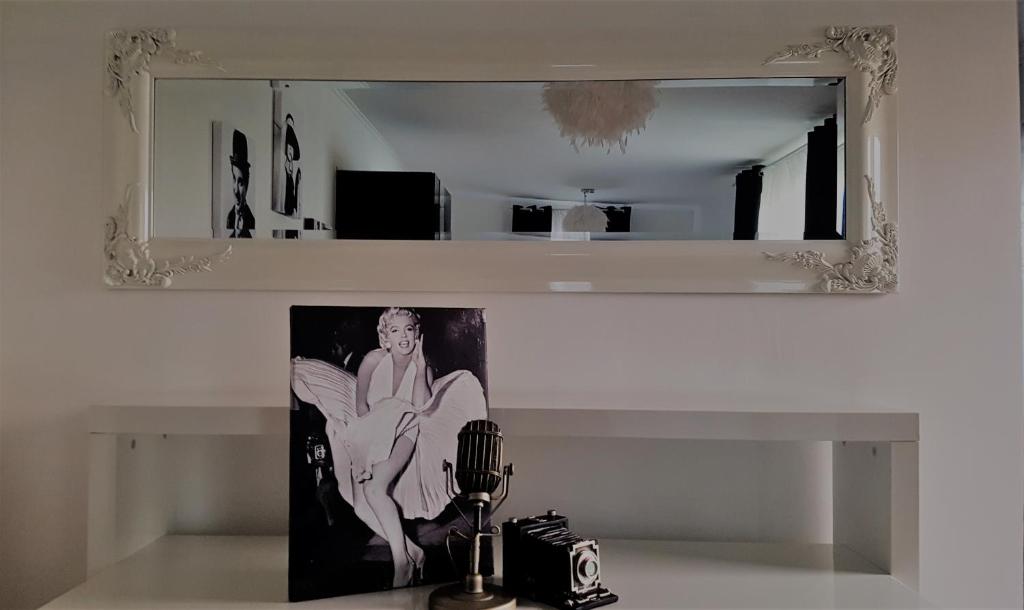 a mirror above a table with a picture and a camera at Kolev Apartments in Kelsterbach