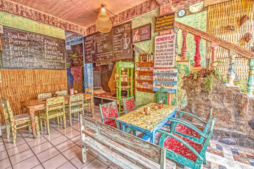 a painting of a restaurant with tables and chairs at Lovina Central Hostel in Lovina