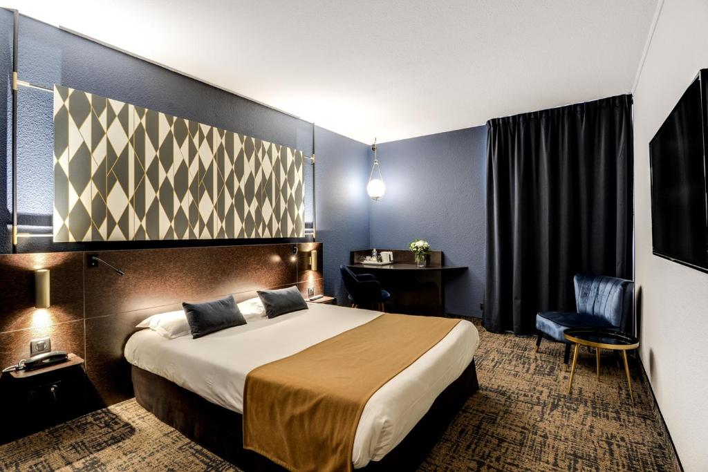 Cette chambre comprend un lit et un bureau. dans l'établissement Brit Hotel Du Stade Rennes Ouest, à Rennes