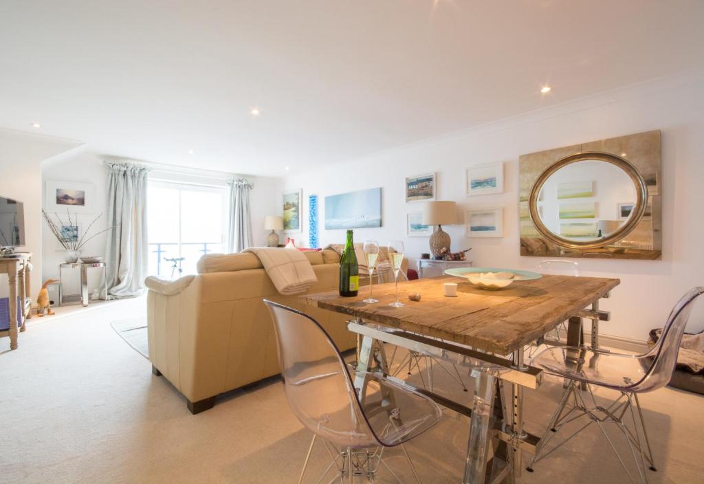 een woonkamer met een tafel en een bank bij Stunning home with breathtaking sea views in Penzance