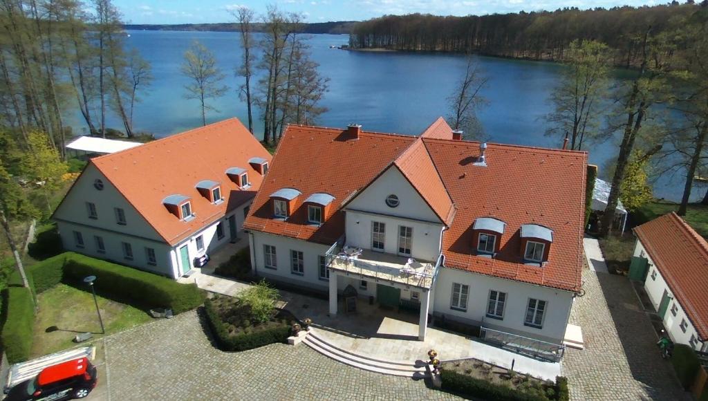 eine Luftansicht eines großen Hauses mit orangefarbenem Dach in der Unterkunft Café Wildau Hotel & Restaurant am Werbellinsee in Schorfheide