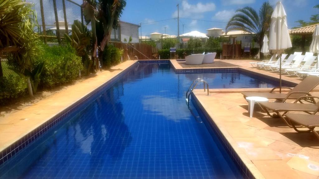 a large swimming pool with blue water in a resort at Quinta das Lagoas Residence in Itacimirim