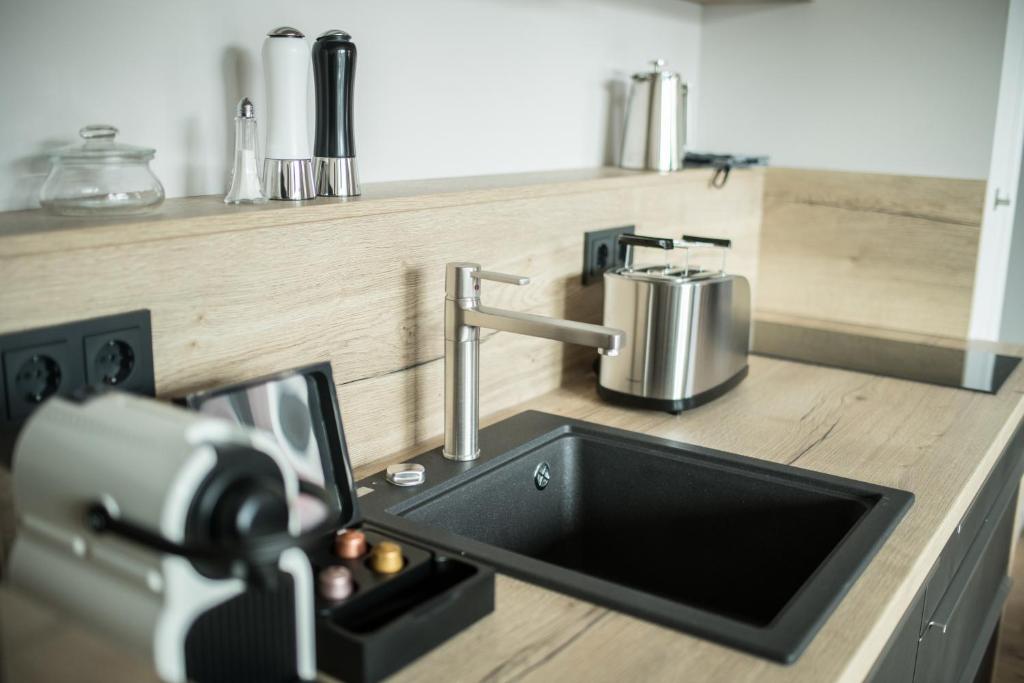 a person taking a picture of a kitchen sink at Suites MITTE - Aparthotel in Eisenach