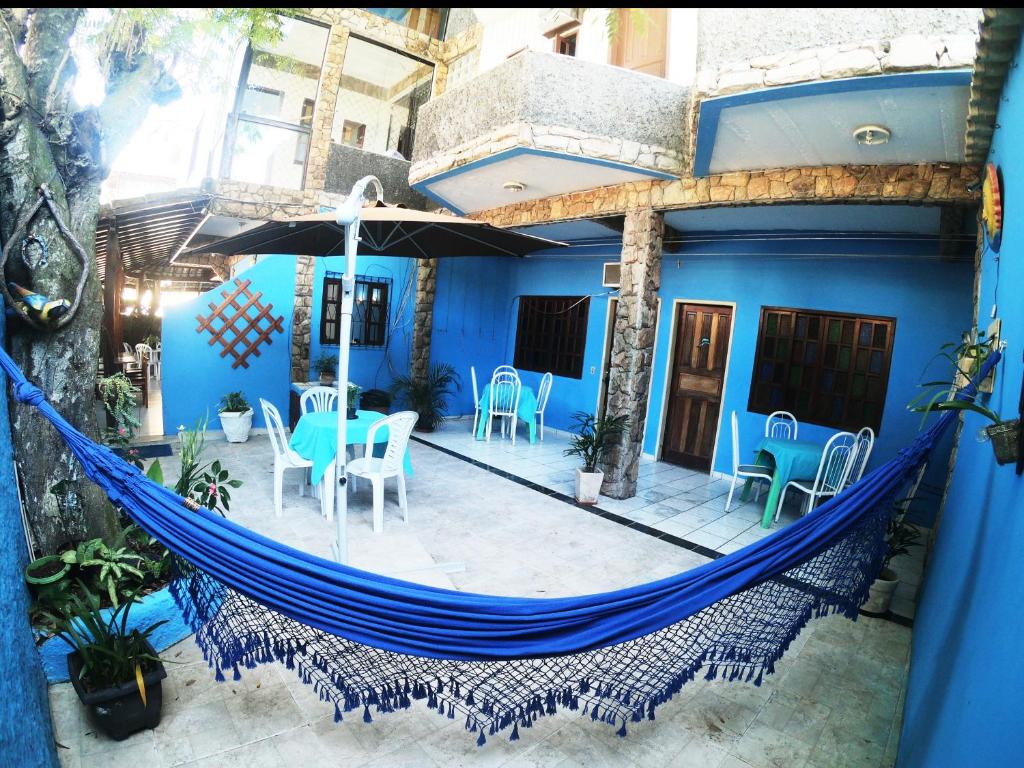 una casa azul con una hamaca en el patio en Pousada Azul do Mar, en Arraial do Cabo