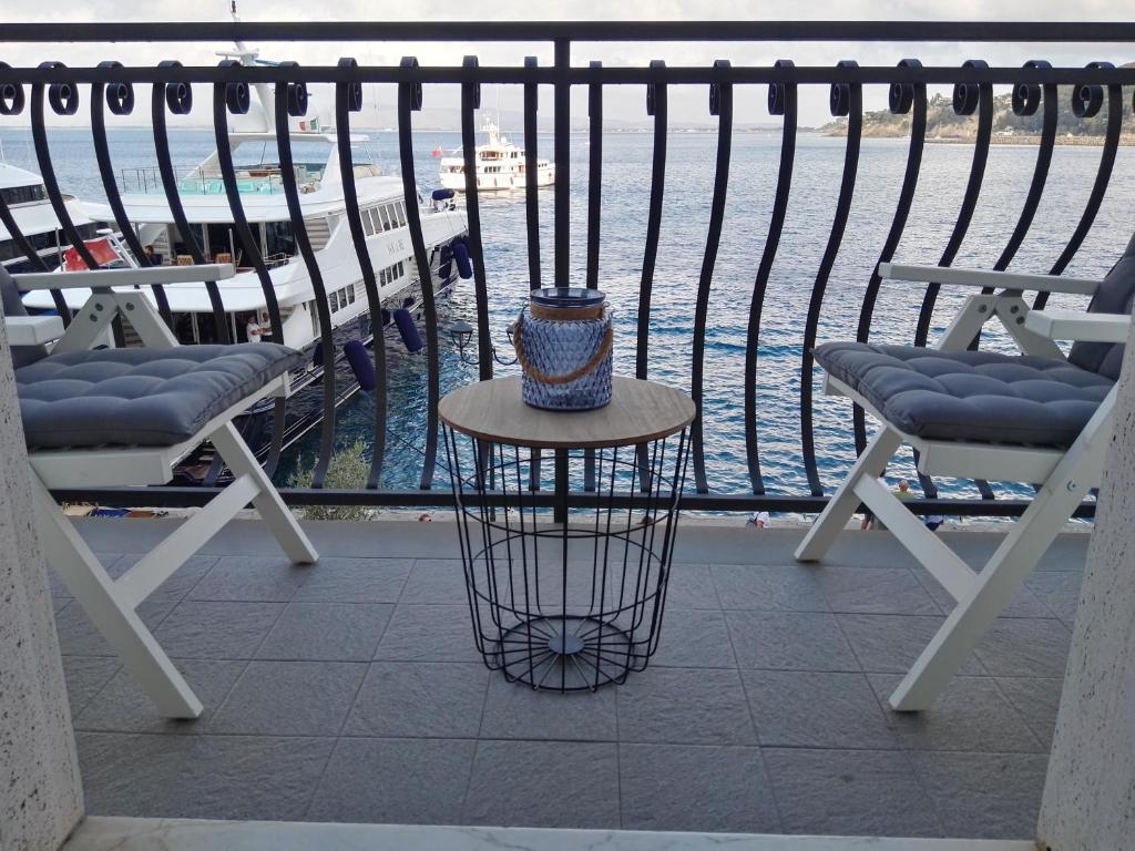 a table and two chairs on a balcony with the water at Molo 41 in Porto Santo Stefano