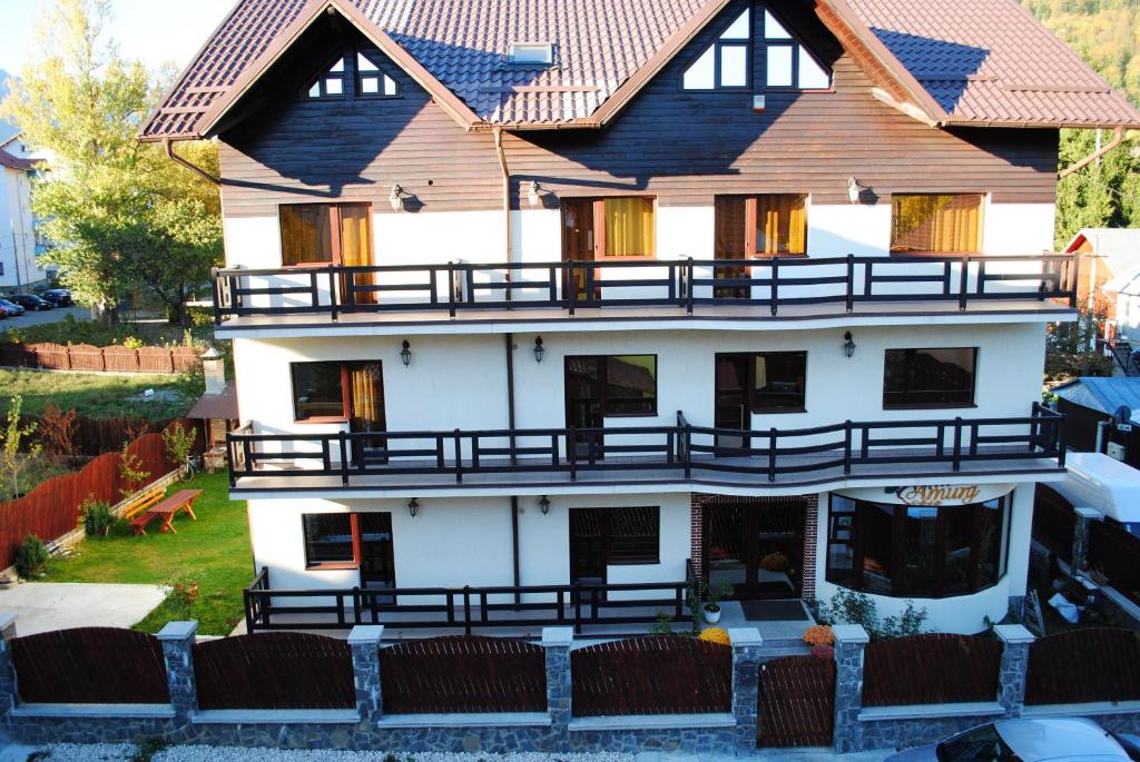 un grand bâtiment blanc avec un toit en bois dans l'établissement Casa Amurg, à Sinaia