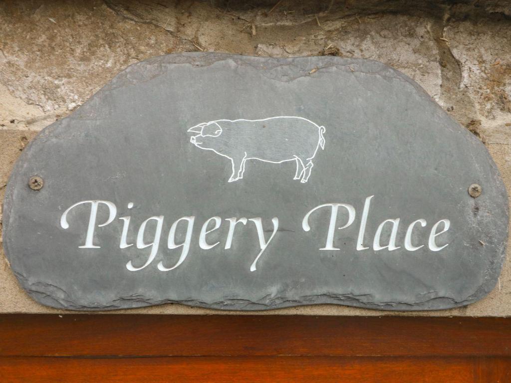 a sign with a drawing of a piggy place at Piggery Place in Buxton