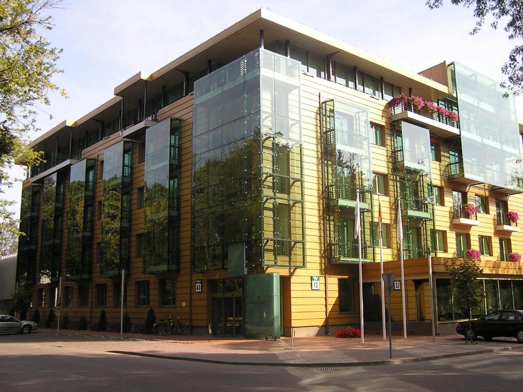 um grande edifício com janelas de vidro numa rua em Grand SPA Lietuva Hotel Druskininkai em Druskininkai
