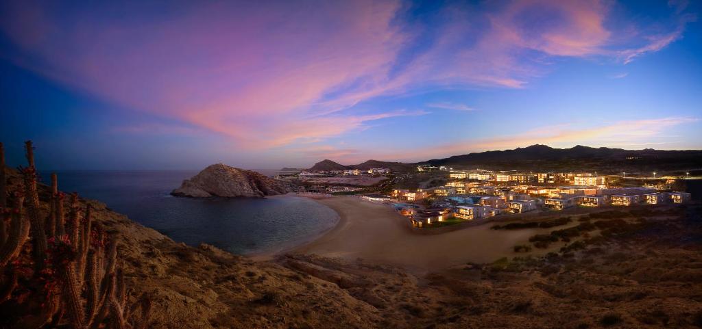 a view of a beach at night with a city at Montage Los Cabos in Cabo San Lucas