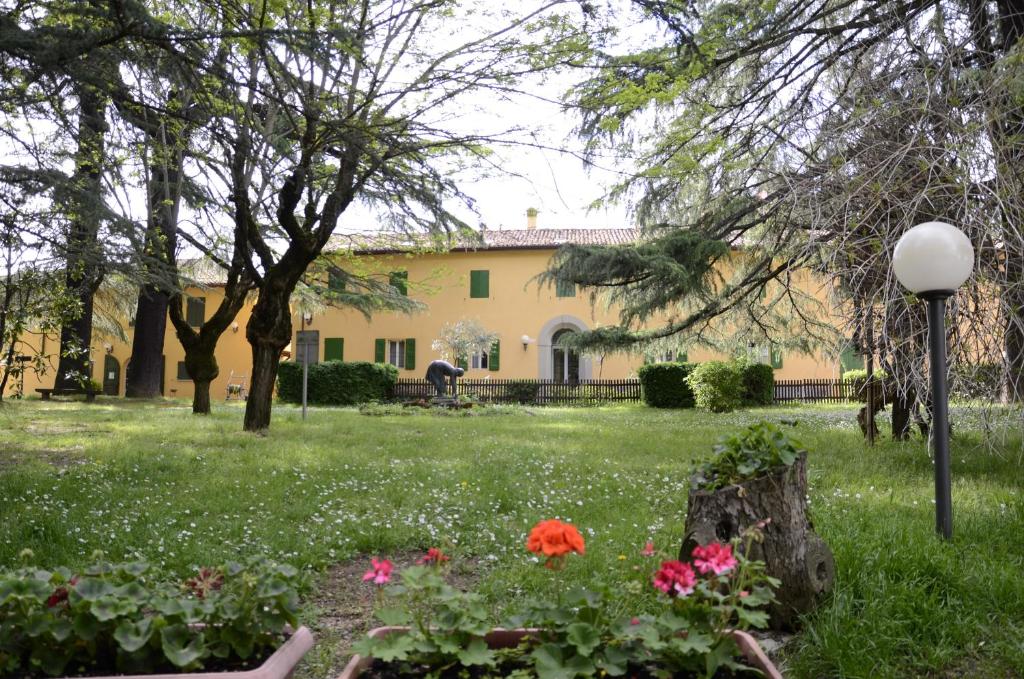 a house with a garden with flowers in the yard at Hotel Ca' Vecchia in Sasso Marconi