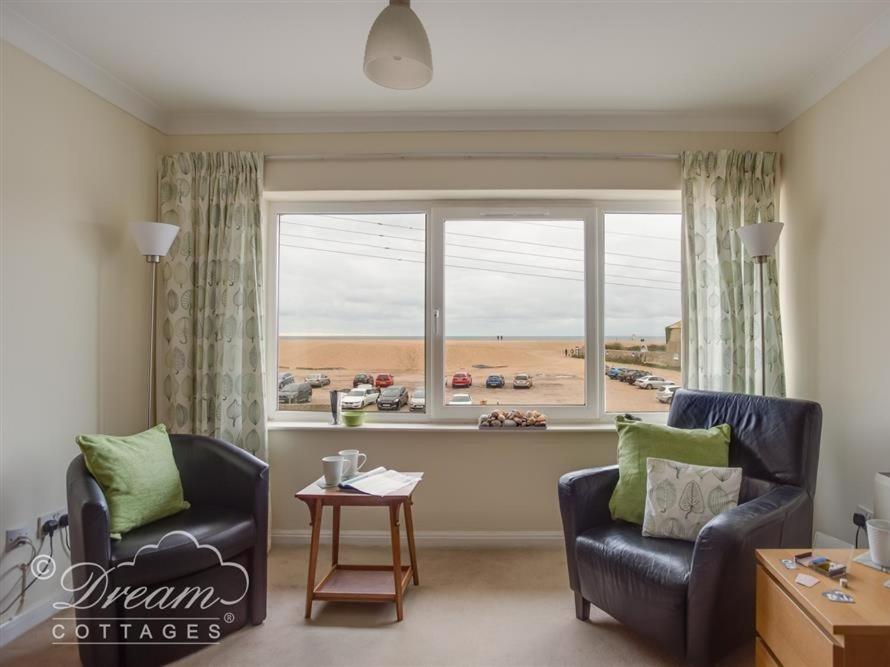 a living room with two chairs and a large window at Jurassic View in West Bay