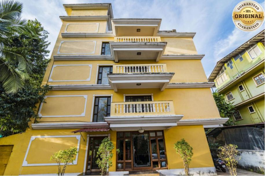 um edifício amarelo com janelas e varandas em Sonikas Holiday Homes (Studio) em Candolim