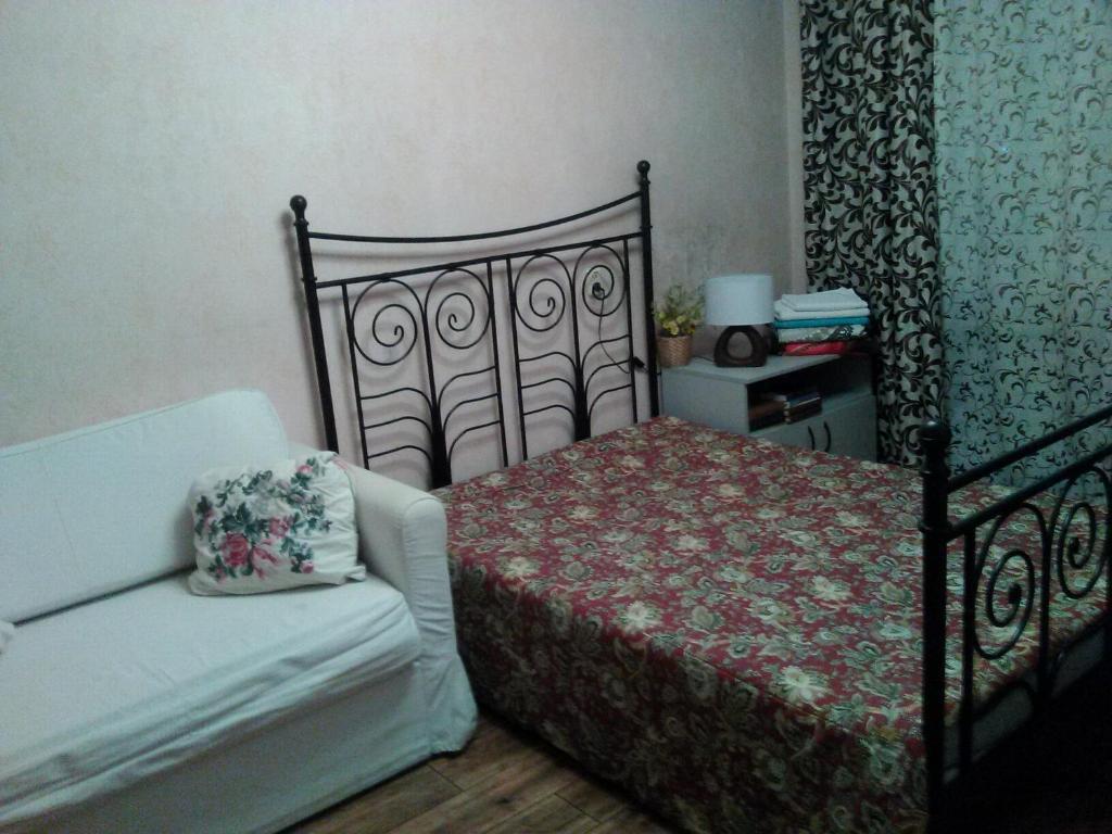 una camera con letto, divano e sedia di Philisa Na Dybenko 24/1 a San Pietroburgo