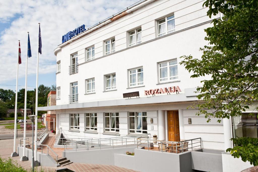 a white building with a sign on it at Kolonna Hotel Rēzekne in Rēzekne